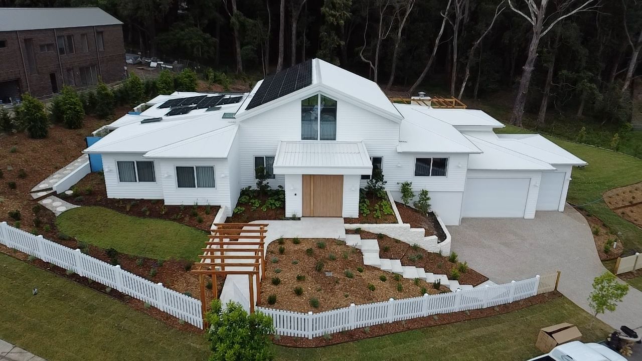A Person Using A Pressure Washer To Clean The House — Jervis Bay Pressure Washing & Property Maintenance In Vincentia, NSW