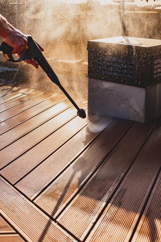 A Person Is Using A Pressure Washer To Clean Deck — Jervis Bay Pressure Washing & Property Maintenance In Sussex Inlet, NSW