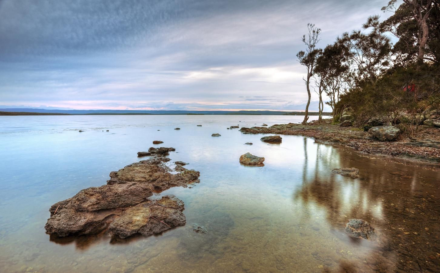 A Body Of Water With Rocks In The Foreground — Jervis Bay Pressure Washing & Property Maintenance In Sanctuary Point, NSW