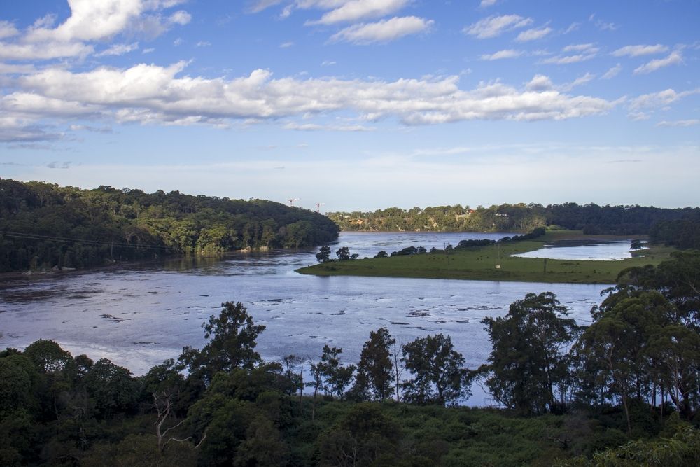A Large Body Of Water Surrounded By Trees On A Sunny Day — Jervis Bay Pressure Washing & Property Maintenance In Nowra, NSW