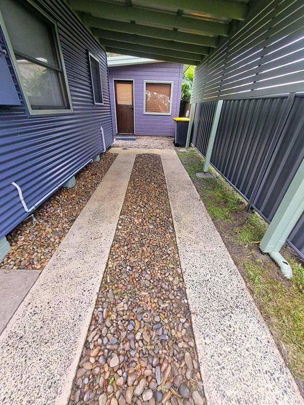 A Concrete Walkway Was Cleaned To A Purple House — Jervis Bay Pressure Washing & Property Maintenance in Jervis Bay, NSW
