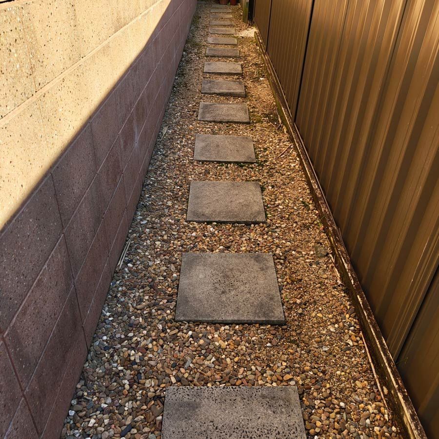 A Row Of Concrete Stepping Stones On Gravel — Jervis Bay Pressure Washing & Property Maintenance in Sussex Inlet, NSW