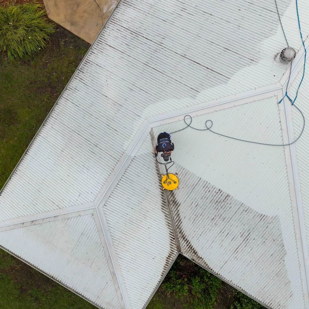 Worker on a White Metal Roof — Jervis Bay Pressure Washing & Property Maintenance in Sanctuary Point, NSW