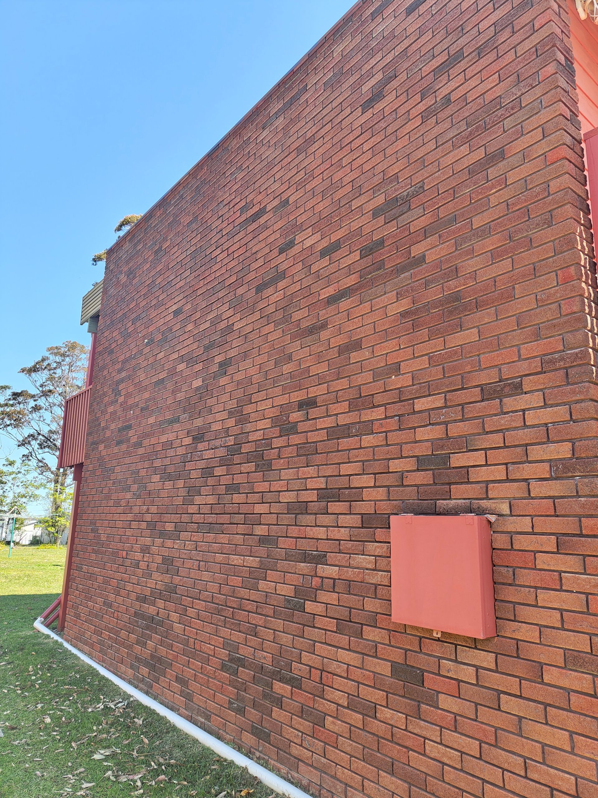 A Newly Cleaned Red Brick Wall With A Red — Jervis Bay Pressure Washing & Property Maintenance in Sanctuary Point, NSW