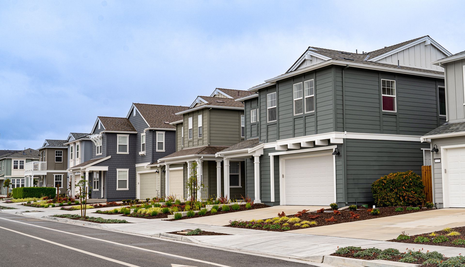 A row of houses are lined up on the side of a road. A row of houses are lined up on the side of a road.