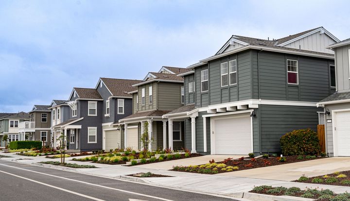 A row of houses are lined up on the side of a road.