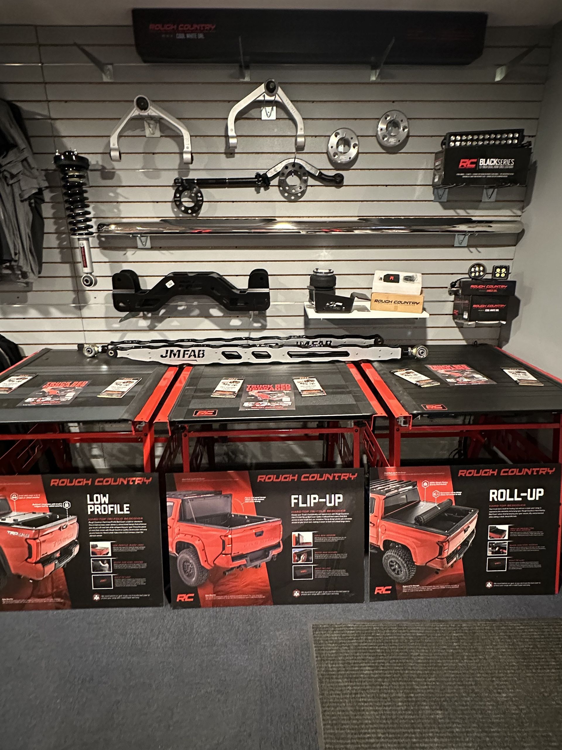 Hardware store display of Black & Decker tools, with boxes of Ryobi mowers and tool accessories on wall racks