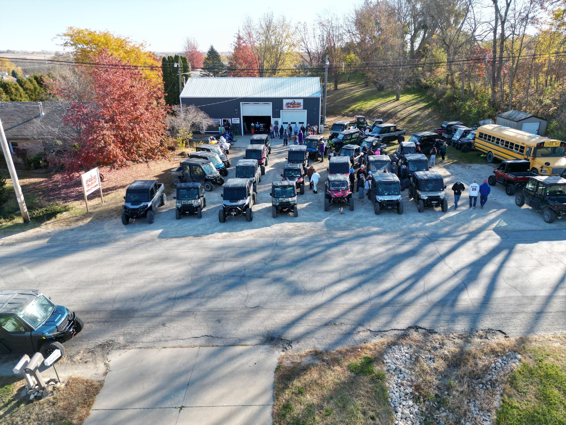 Autumn parking lot full of parked cars outside a building, viewed from above.