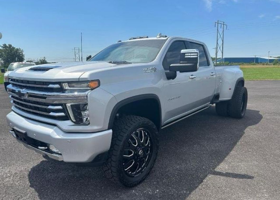 White heavy-duty pickup truck parked on an asphalt lot under a clear sky