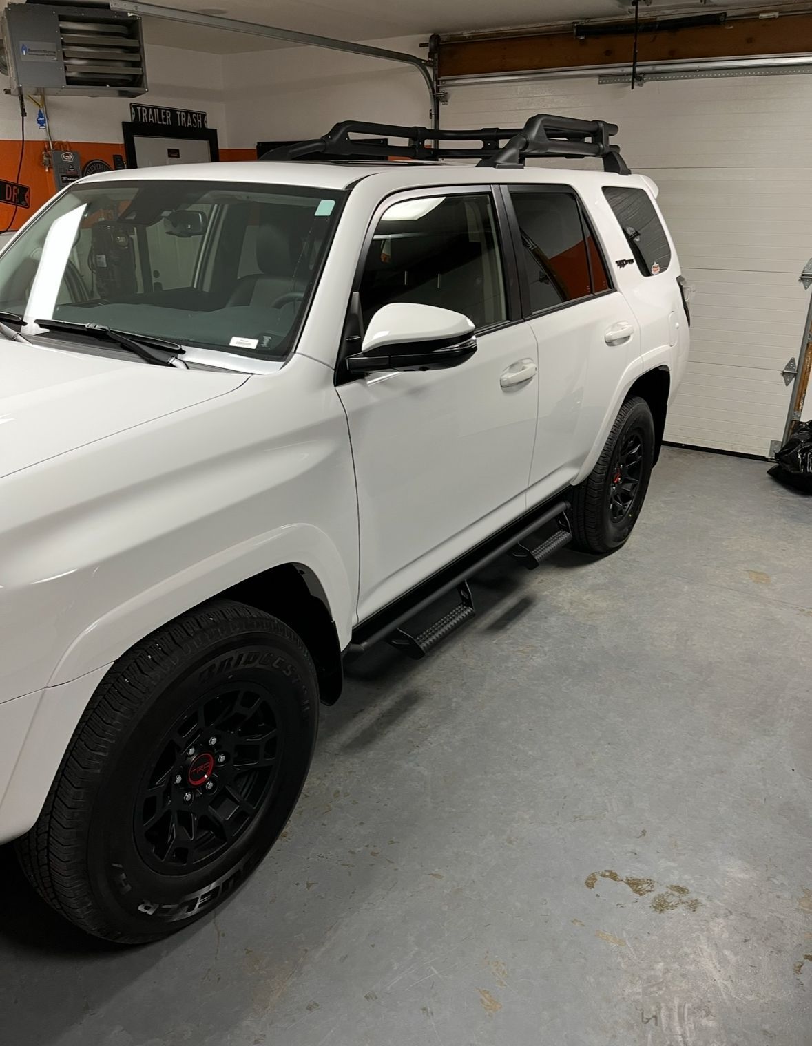 White SUV parked inside a garage, shown from the front-left side.