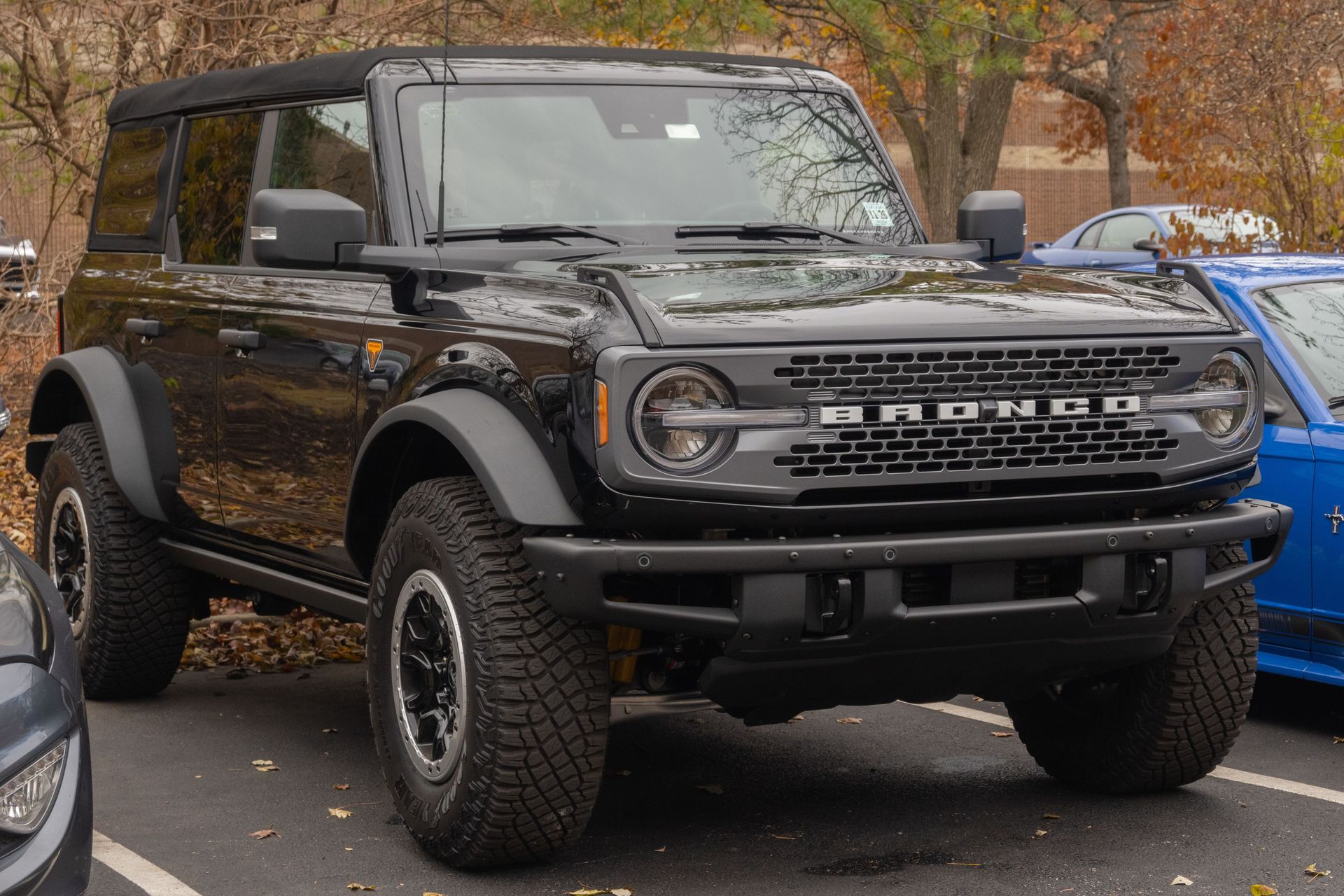 Black Ford Bronco parked outdoors on a leafy street, front view with off-road tires.