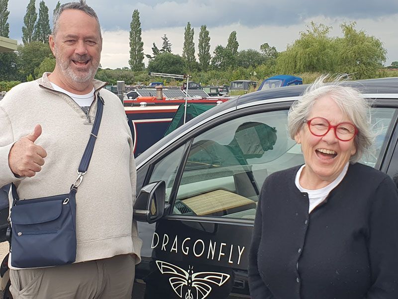 A photo of Tim and Paula standing by the dragonfly car.