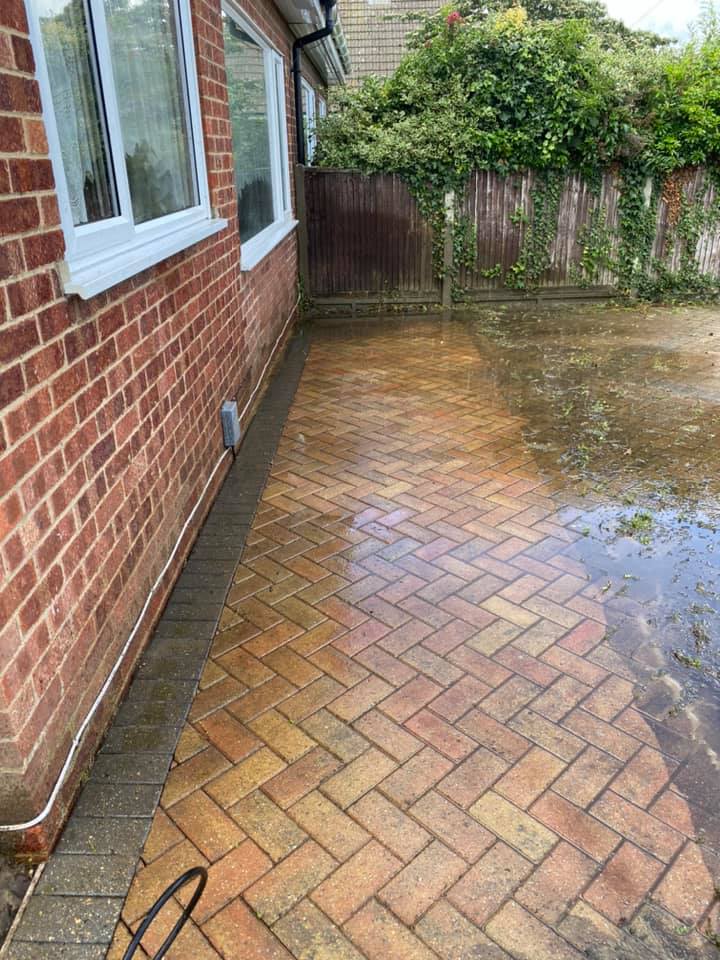 a brick walkway is being cleaned in front of a brick house, after cleaning