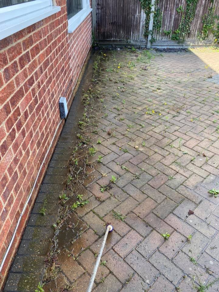 a brick driveway with a hose attached to it in front of a brick building, before cleaning