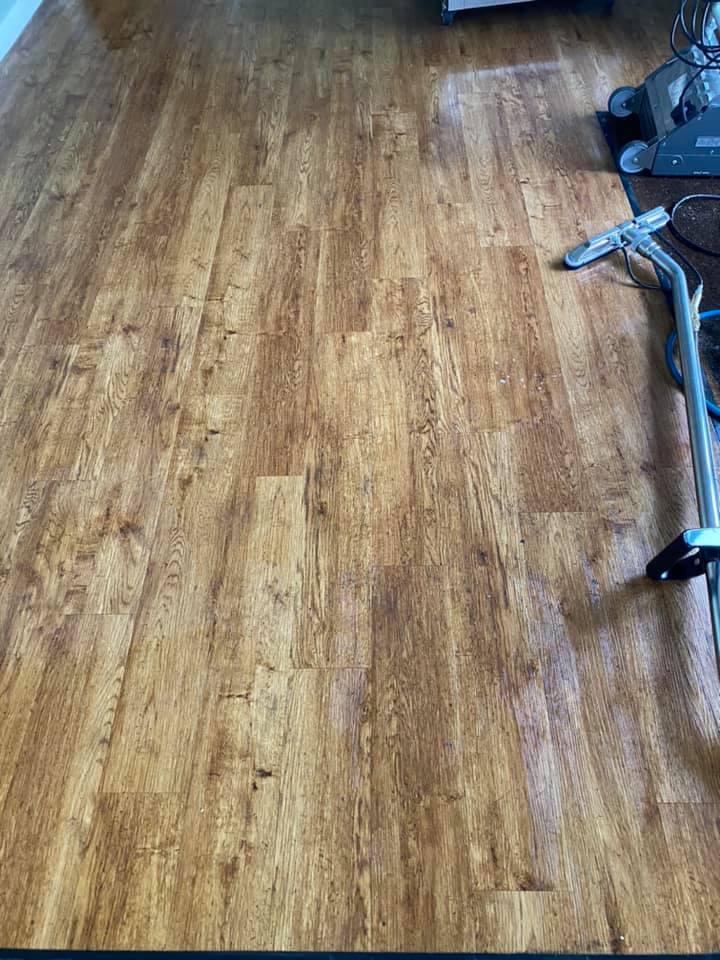 a vacuum cleaner is sitting on a wooden floor in a living room .