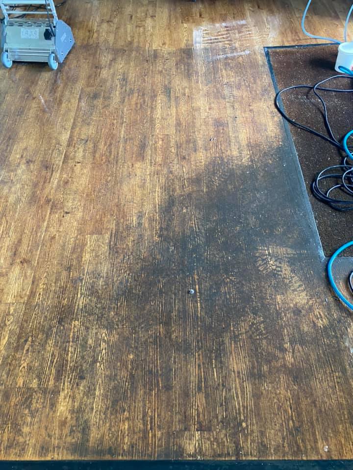 a wooden floor with a rug and a vacuum cleaner on it .