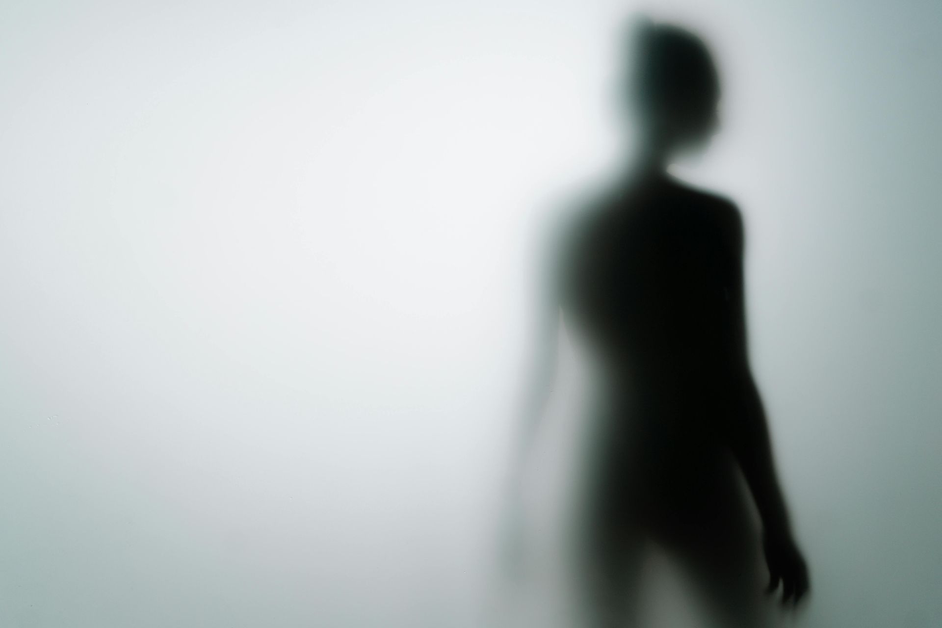 black silhouette of a body against a grey background