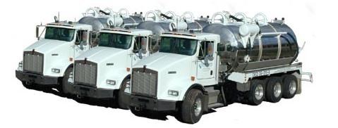 Three White Trucks – Kalamazoo, MI – Clean Earth Environmental Contracting Services White tanker trucks lined up, each with a cylindrical tank, likely for carrying liquids.