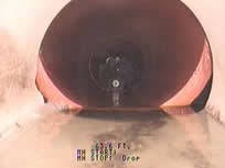 A dark, round object on a light surface, with a small, metallic element in the center. Text at the bottom.