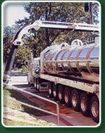Liquid Waste Truck – Kalamazoo, MI – Clean Earth Environmental Contracting Services A tanker truck with a long arm emptying contents, likely from a septic system, into a wastewater treatment facility.