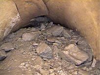 Pile of rocks in a cave, lit dimly.