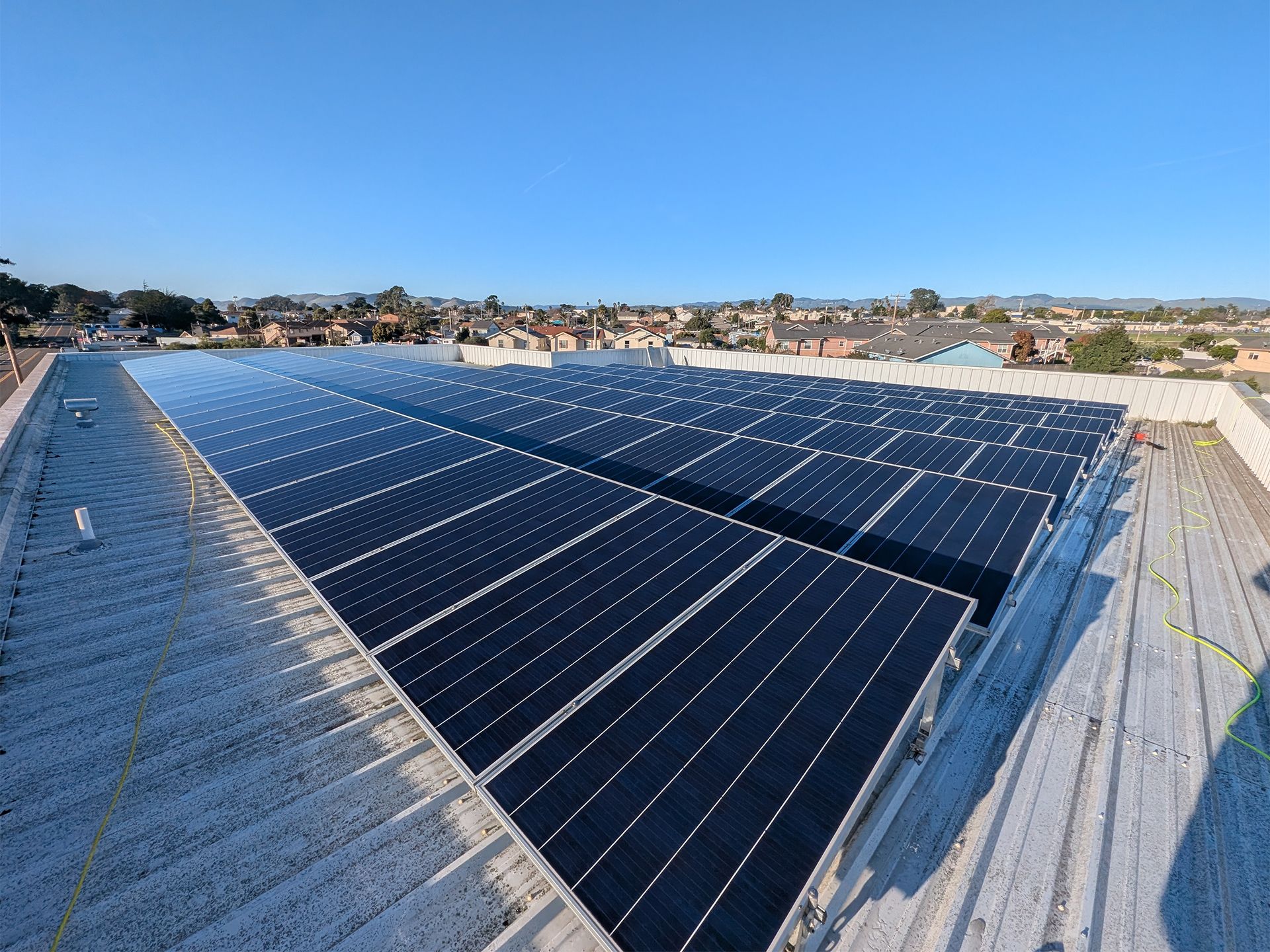 Solar panels installed on a rooftop under a clear blue sky.