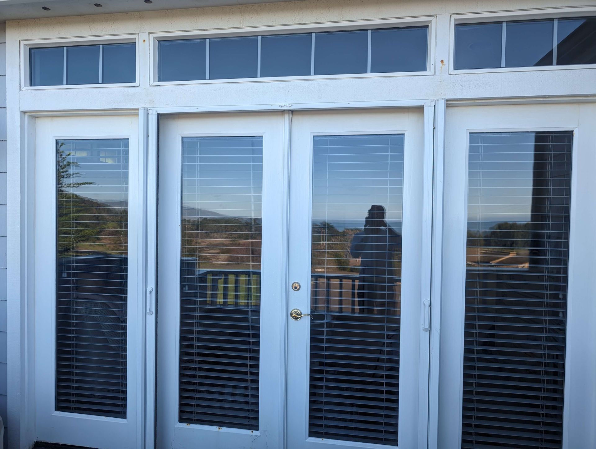 A white sliding glass door with blinds on it