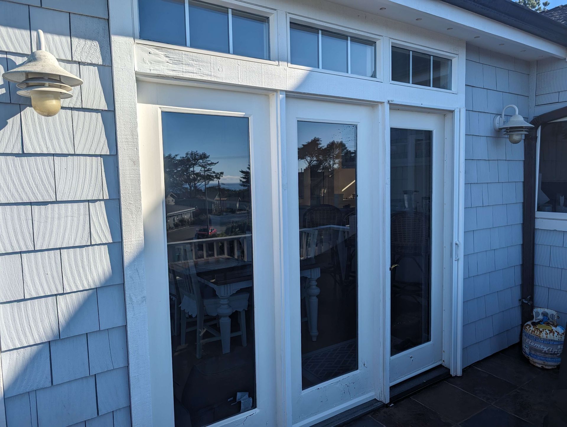 A white sliding glass door on a blue house