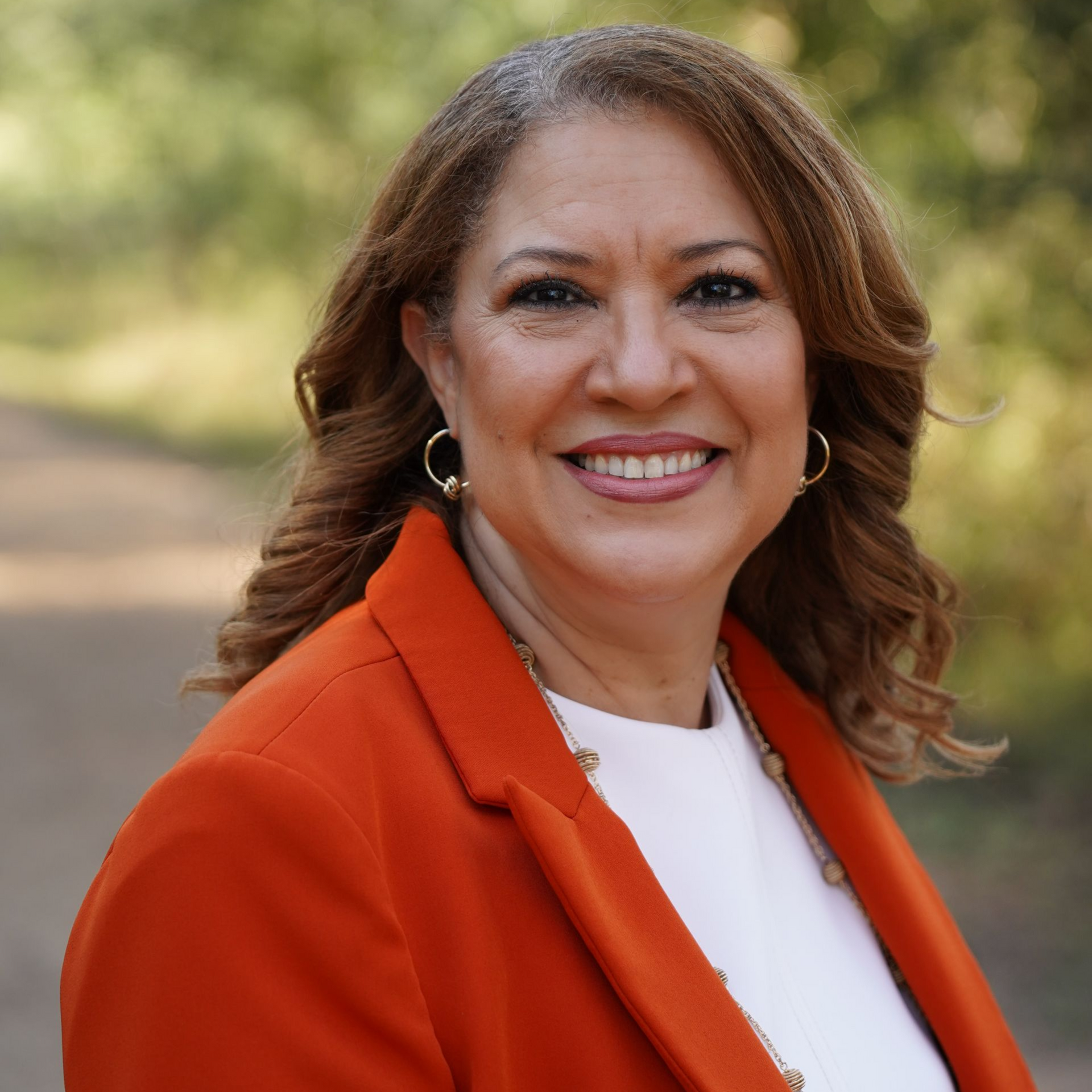A woman wearing a green and white checkered shirt is smiling.