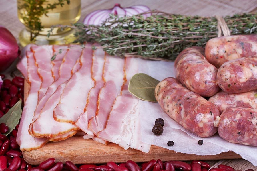 A Bacon Slices, Sausage Links, Thyme, and Red Beans on a Wooden Board — Paddock to Plate in Tamworth, NSW