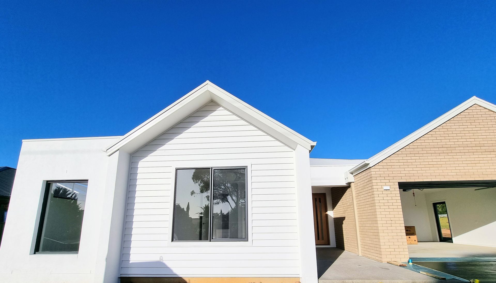 A Man Is Painting A Window In A Room With Lots Of Windows — Crampton Painting & Decorating Pty Ltd In Maiden Gully, VIC