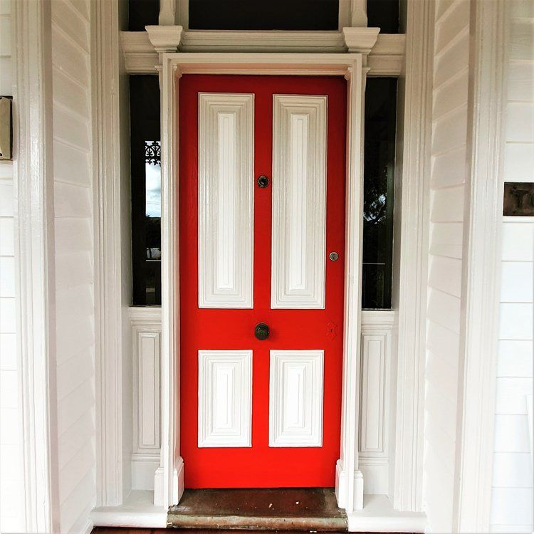 A Red Door With White Trim On A White House — Crampton Painting & Decorating Pty Ltd In Maiden Gully, VIC