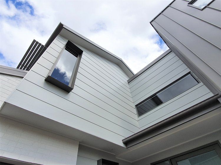 A House With A Lot Of Windows On The Side Of It — Crampton Painting & Decorating Pty Ltd In Maiden Gully, VIC