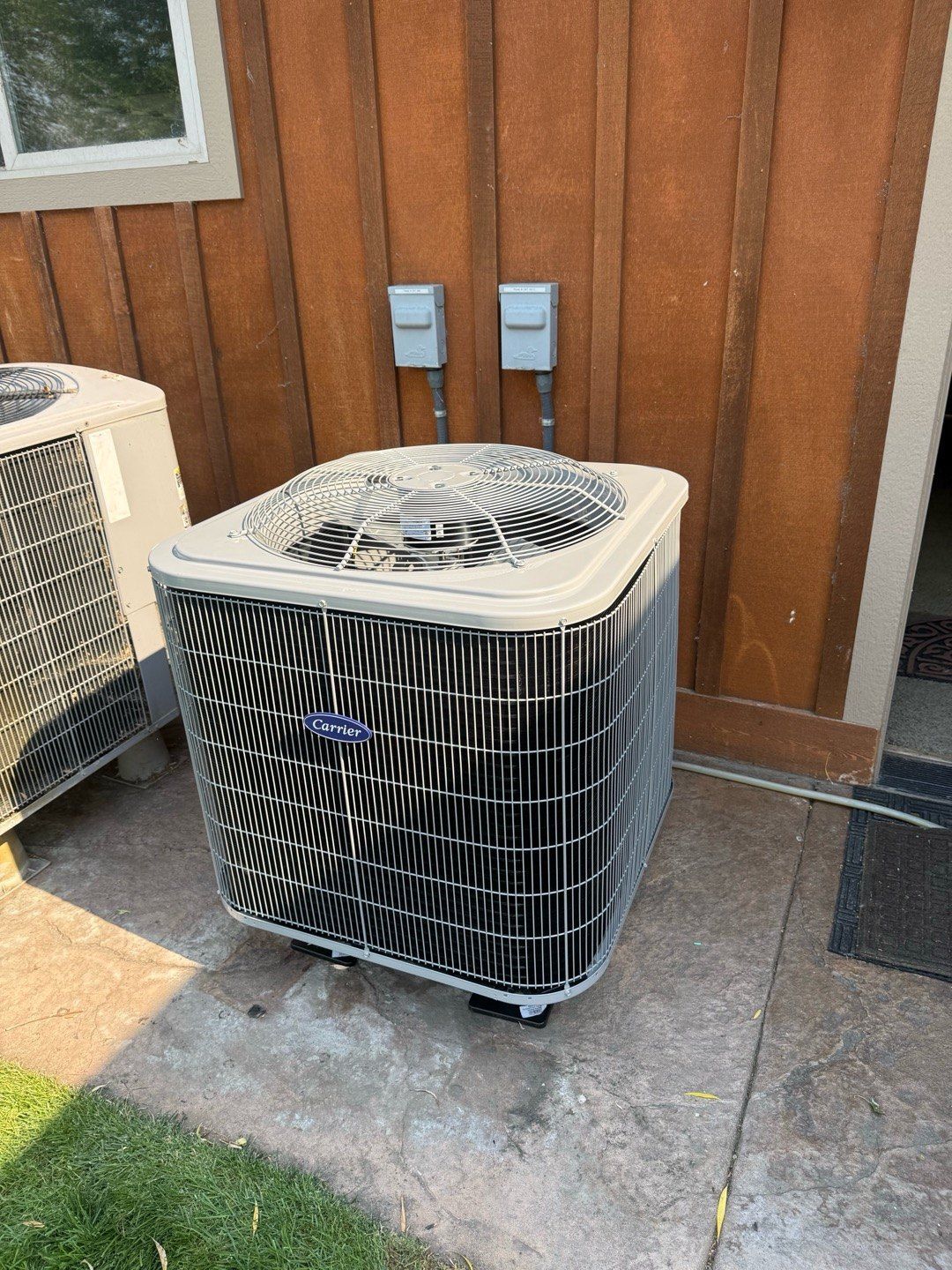 New Carrier heat pumps on concrete pads, installed by Alpine Aire at a home in East Wenatchee, WA