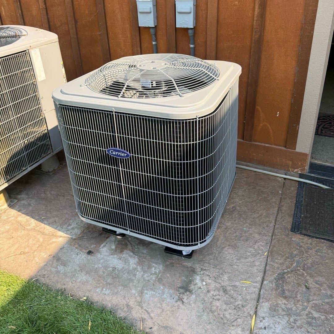 Carrier heat pump outdoor unit installed by Alpine Aire on a concrete pad beside a home in East Wenatchee, WA