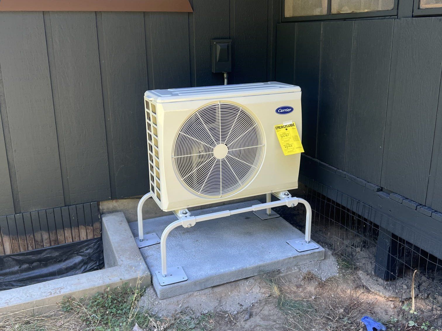 New Carrier heat pump on a raised stand and concrete pad, installed by Alpine Aire at a home in Leavenworth, WA