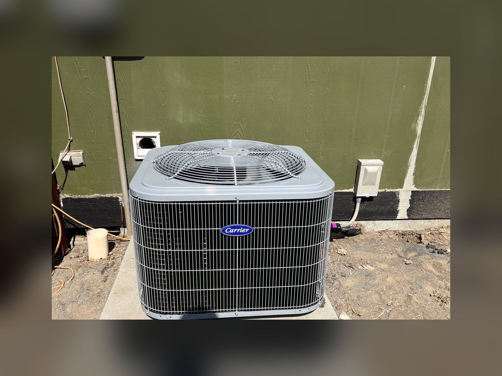 New Carrier heat pump on a concrete pad, installed by Alpine Aire at a home in Quincy, WA