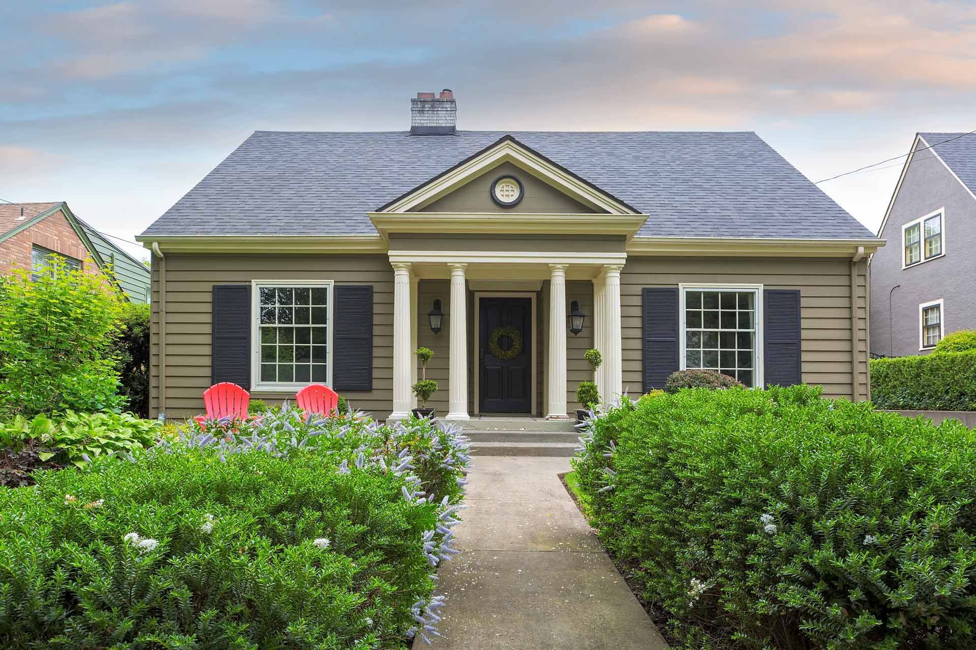 A house with a porch and shutters on the windows is for sale