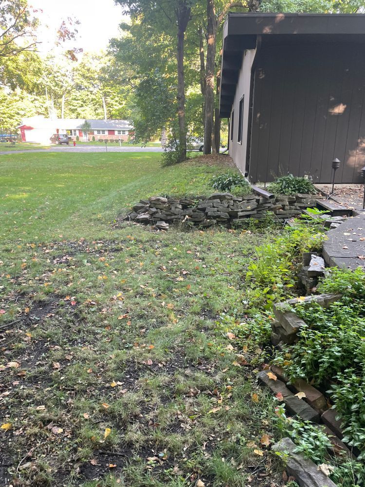 A house with a lot of grass and rocks in front of it