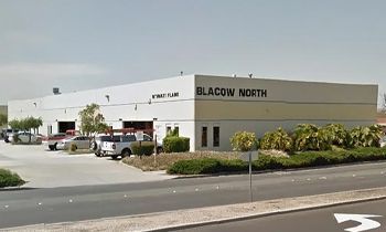 A large white building with a lot of cars parked in front of it.