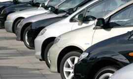 A row of cars are parked in a parking lot.