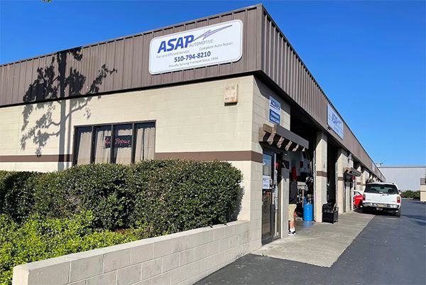 ASAP storefront on a sunny street, with beige exterior, blue sign, and parked car beside the entrance