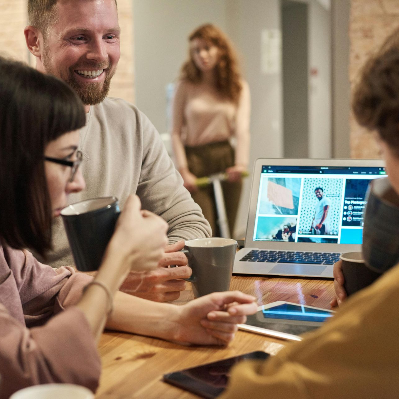 Un groupe de personnes collabore autour d'un ordinateur portable dans un bureau confortable