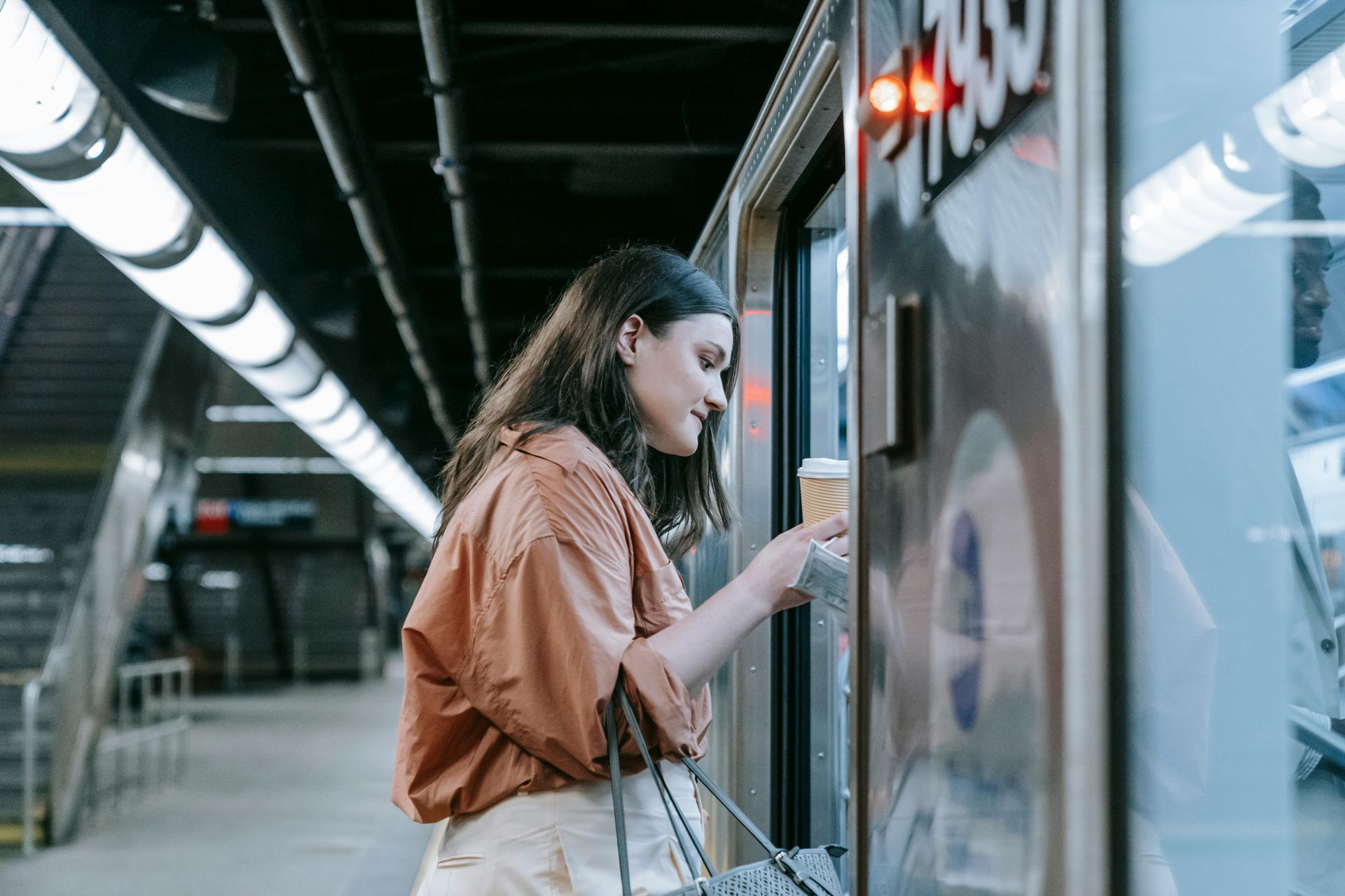 Une femme parle dans un kiosque sur un quai de métro