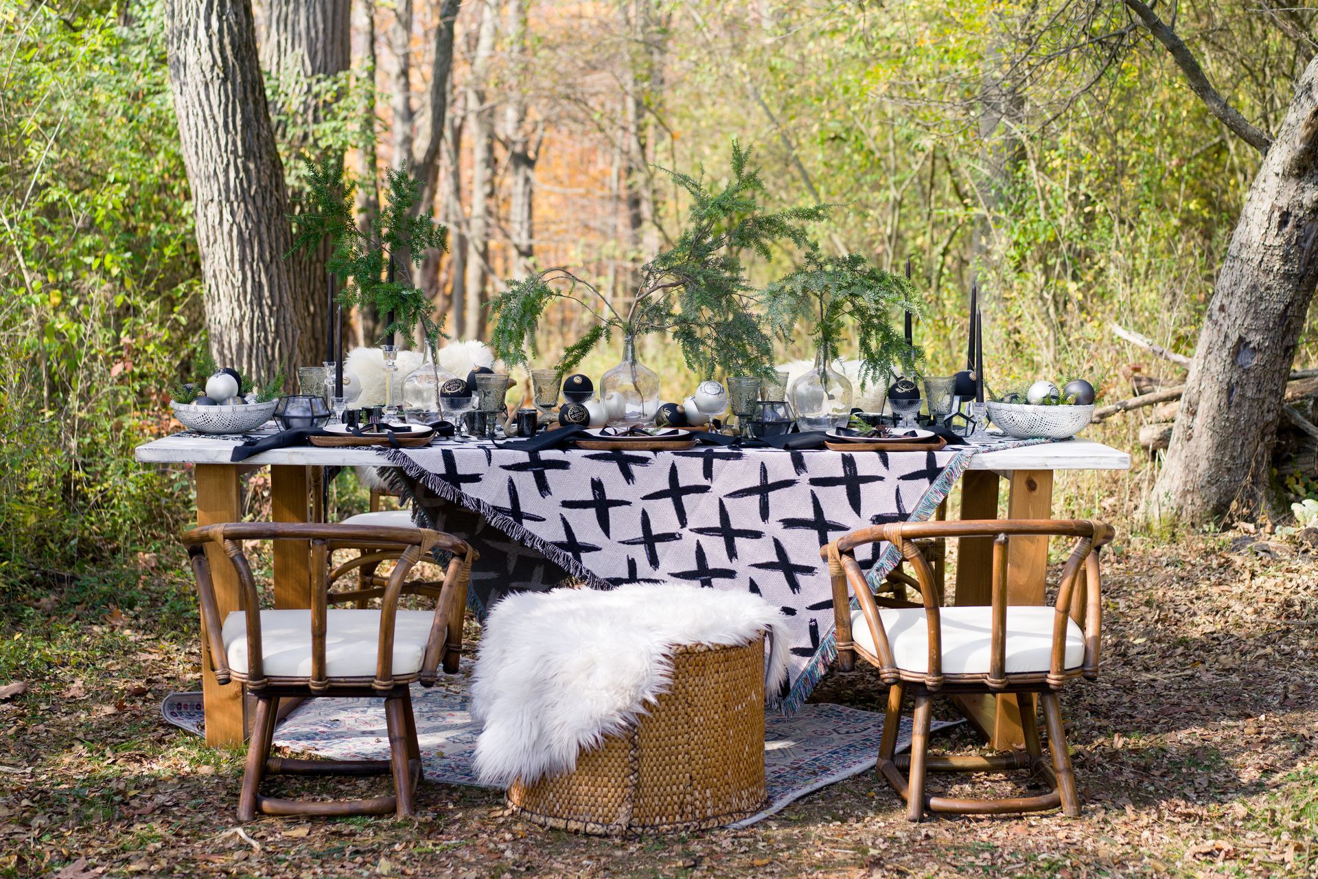 A table and chairs in the middle of a forest.