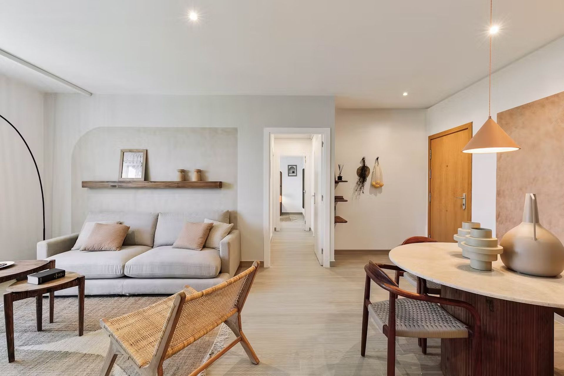 Bright modern living room with beige sofa, woven chairs, round table, and wood accents Bright modern living room with beige sofa, woven chairs, round table, and wood accents