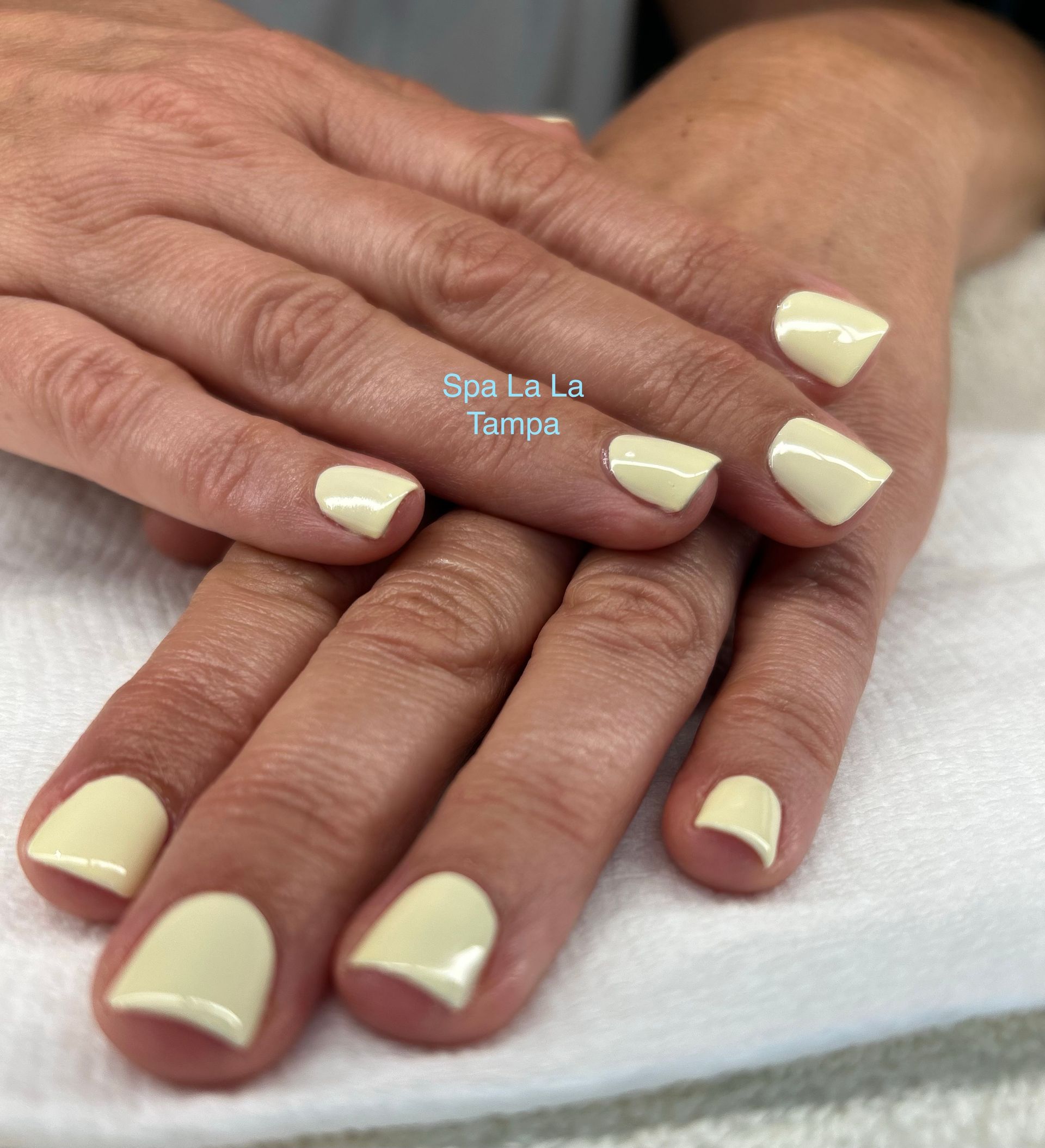 Hands with dazzle dry nail polish. Light yellow dazzle dry nail polish manicure.