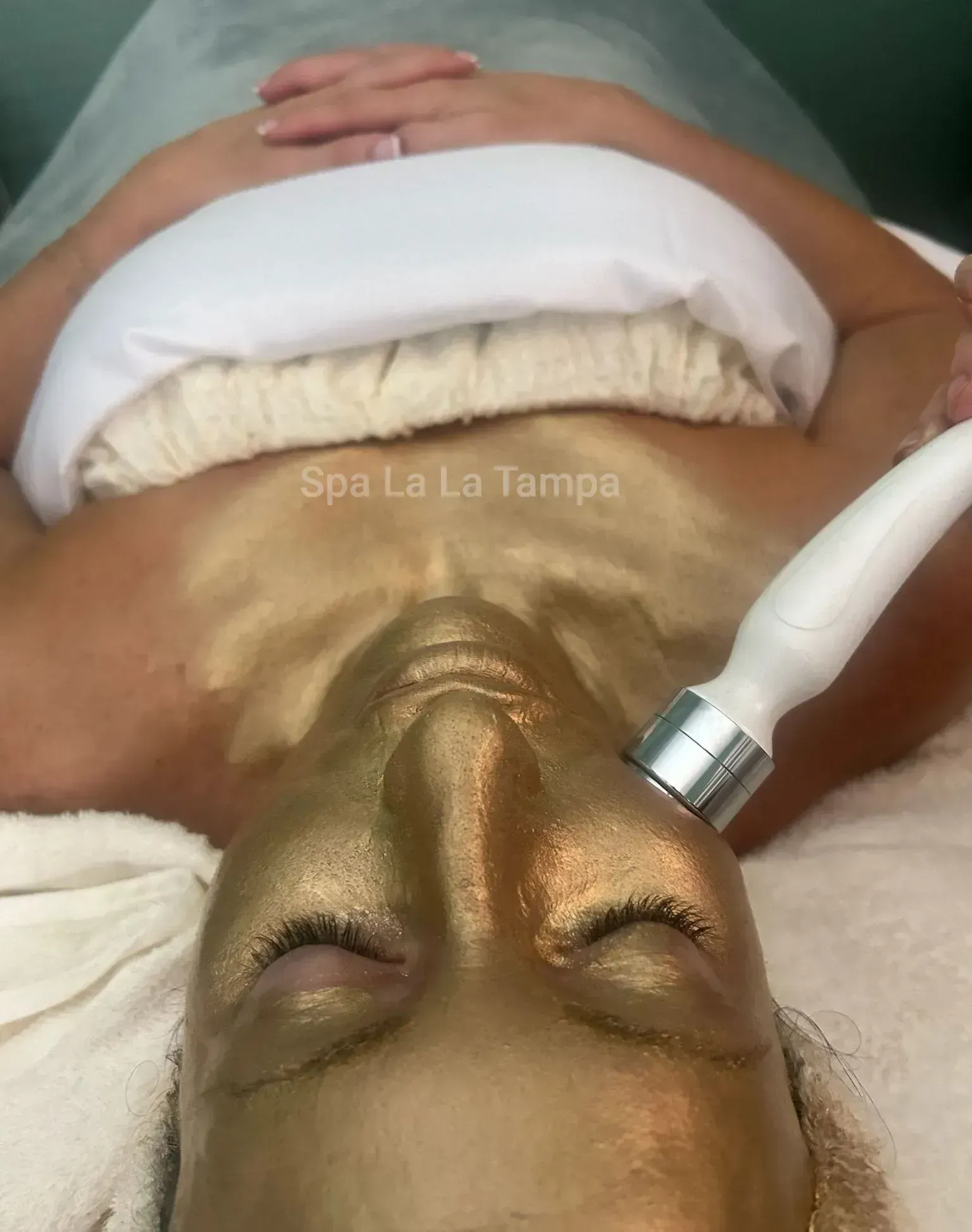 Woman receiving a facial with a gold mask. Woman receiving a facial with a gold mask.