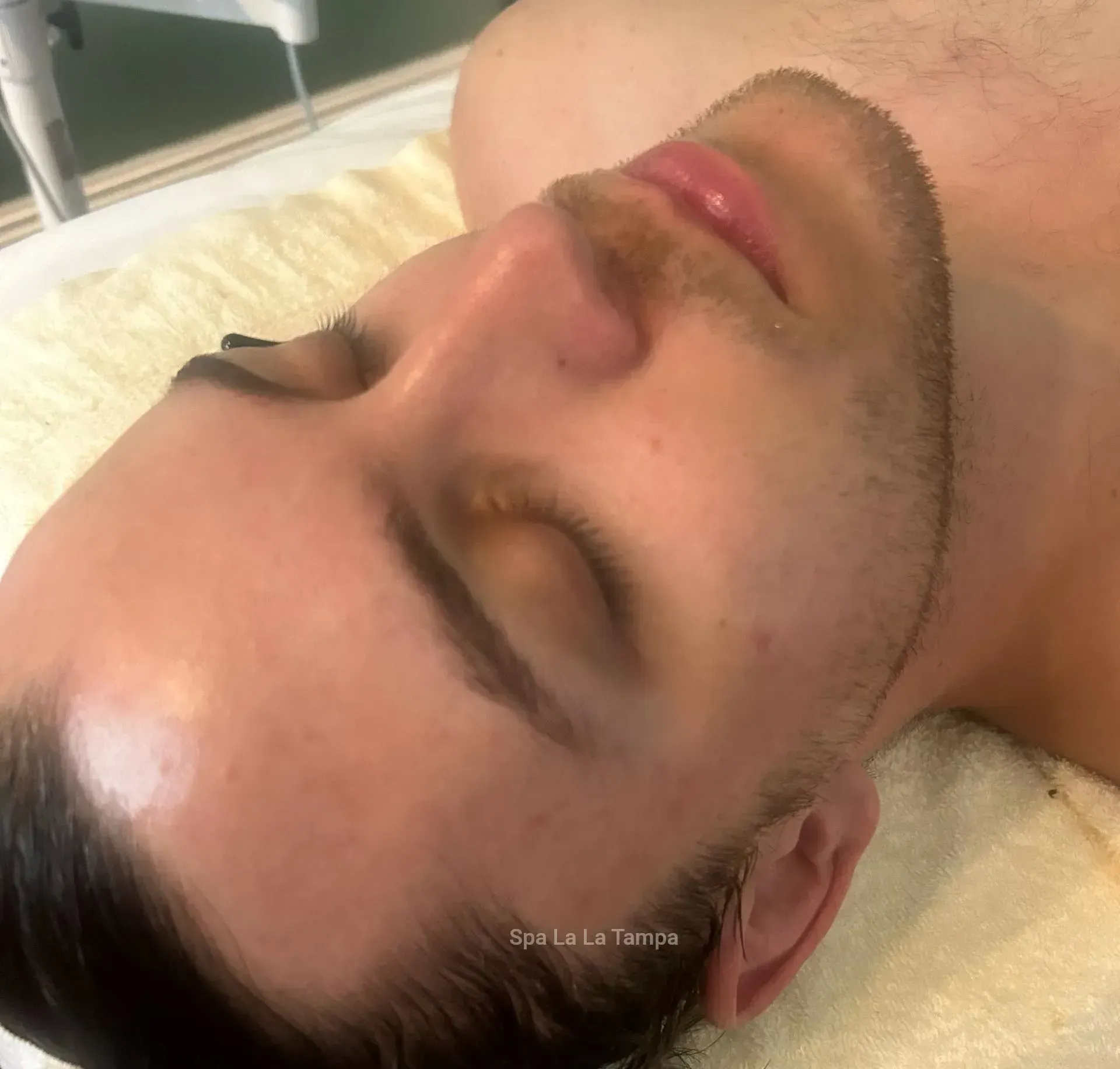 Man with short brown beard and closed eyes, receiving facial treatment. Man with short brown beard and closed eyes, receiving facial treatment.