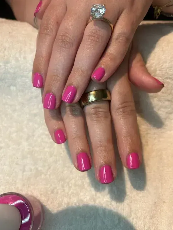 Hands with vibrant pink nail polish and rings. Hands with vibrant pink nail polish and rings.